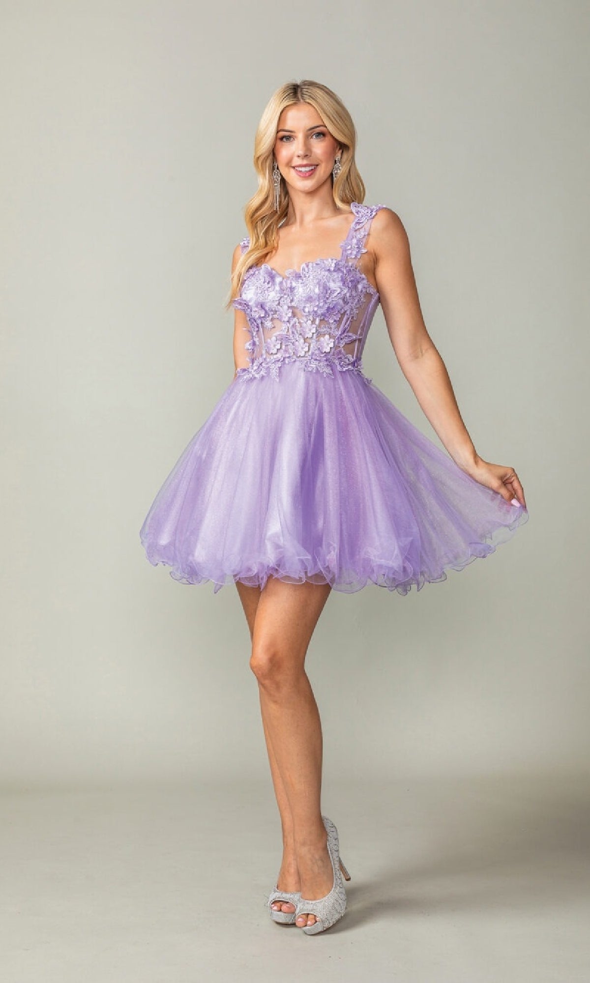 Woman wearing a lilac short dress with floral embellishments on a plain background